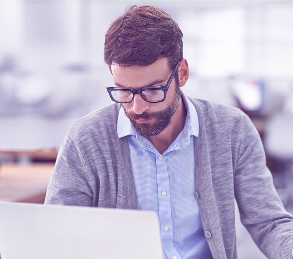 Foto de um homem concentrado utilizando notebook.