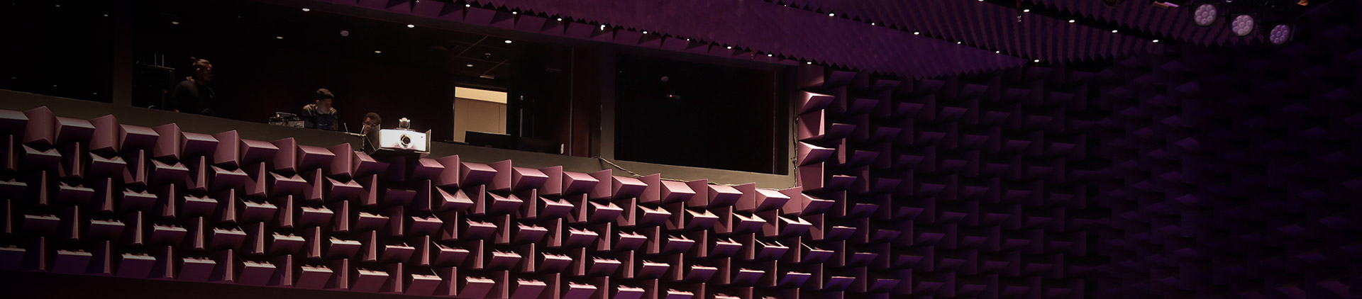 Foto do revestimento acústico, geométrico em relevo da parede da sala de espetáculo do Teatro Vivo.