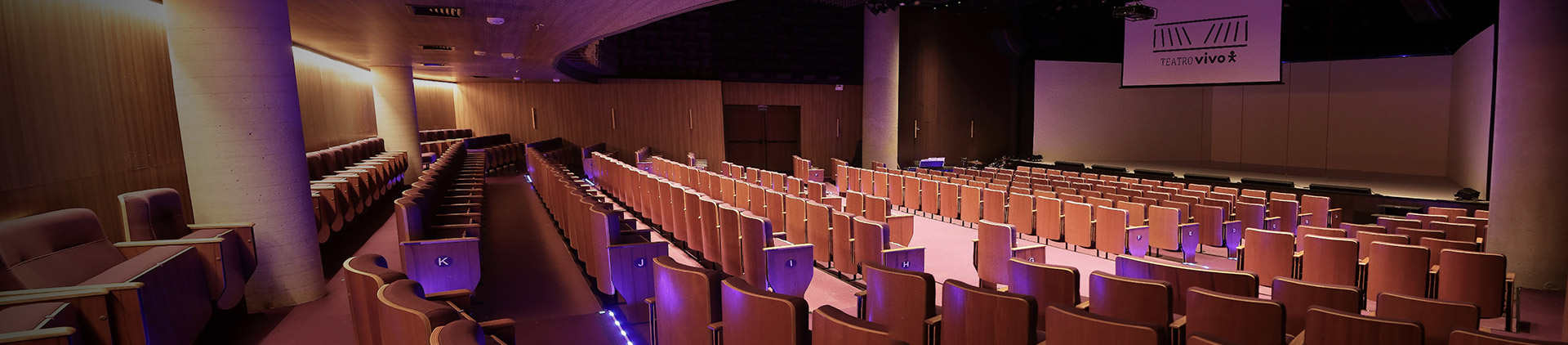 Fotografia da sala de espetáculo do Teatro Vivo, do ponto de vista da plateia para o palco.