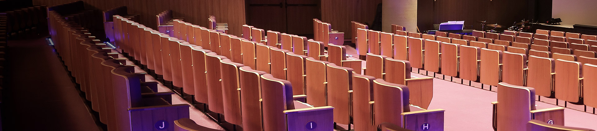 Fotografia dando destaque às poltronas da sala de espetáculo do Teatro Vivo