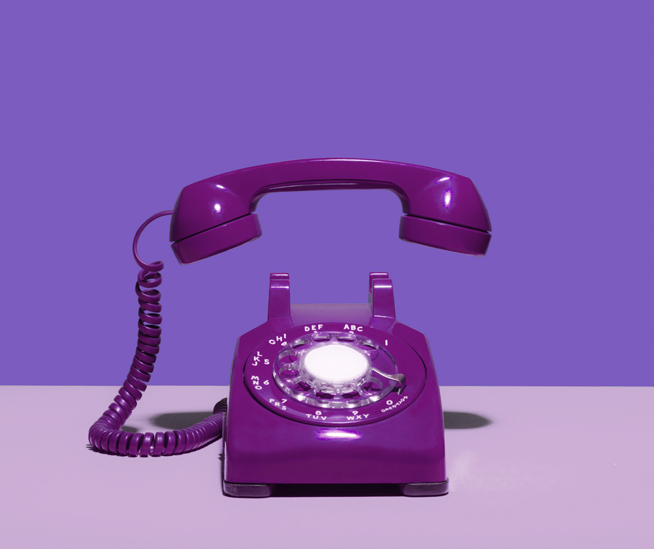 Telefone fixo pintado de roxo. Ele está tocando