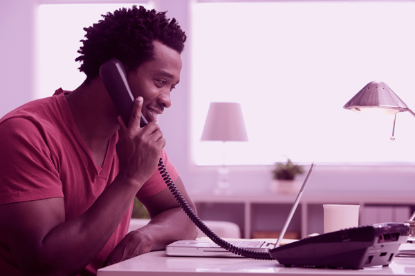 Imagem de homem usando telefone fixo