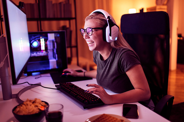 Imagem de uma mulher sorrindo enquanto participa de uma videochamada realizada no computador.