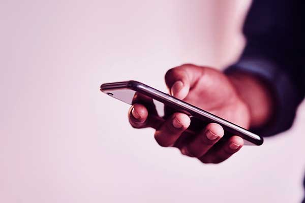 Pessoa mexendo no celular atualizando o sistema operacional. 