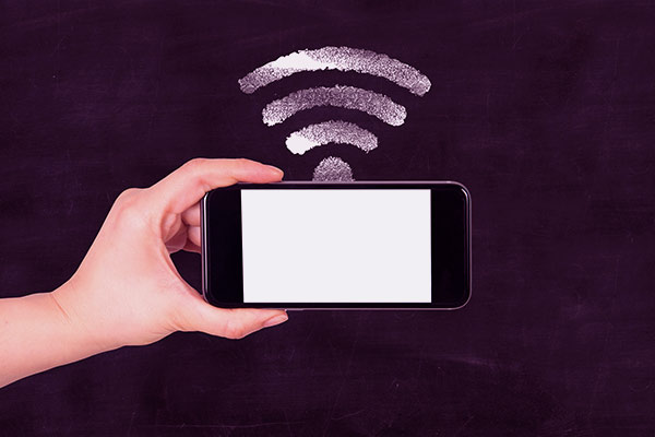 Mão segurando um celular com símbolo de wi-fi em cima