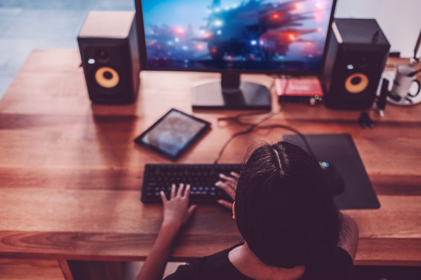 Imagem de uma pessoa jogando em um computador de mesa.