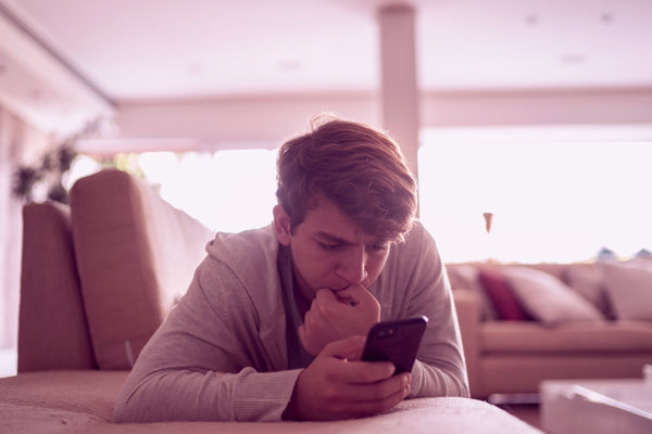 Imagem de um homem olhando preocupado para o celular.
