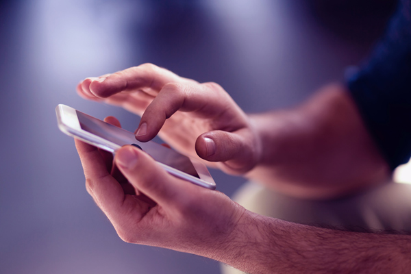 Imagem de um homem utilizando um smartphone,