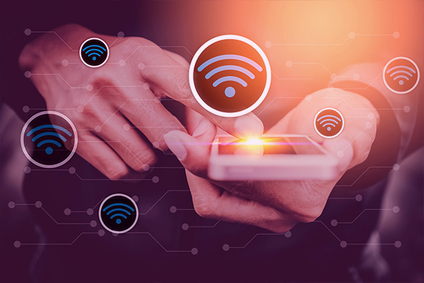 Imagem de uma pessoa usando um celular. Flutuam ícones de wi-fi.