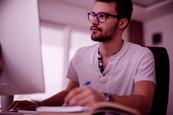 Imagem de um homem mexendo em um computador.