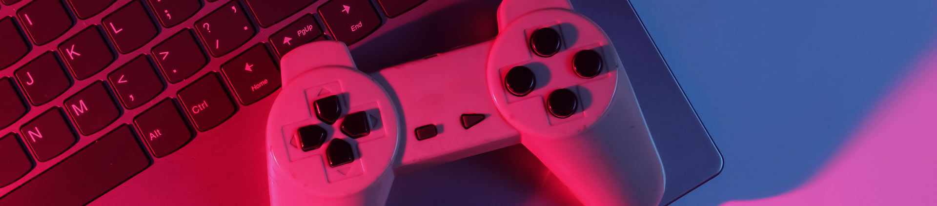 Imagem de um controle de videogame sobre o teclado de um notebook.