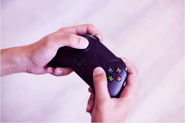 Imagem de mãos masculinas segurando um controle de videogame.