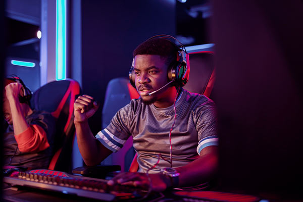 Jovem com punho fechado comemorando gamecoin recebidas no jogo NFT