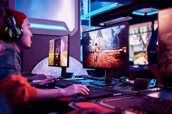Menino jogando jogo multiplayer em seu computador gamer. 