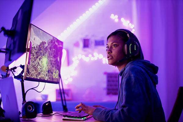 Menina com seu computador gamer jogando NFT. 