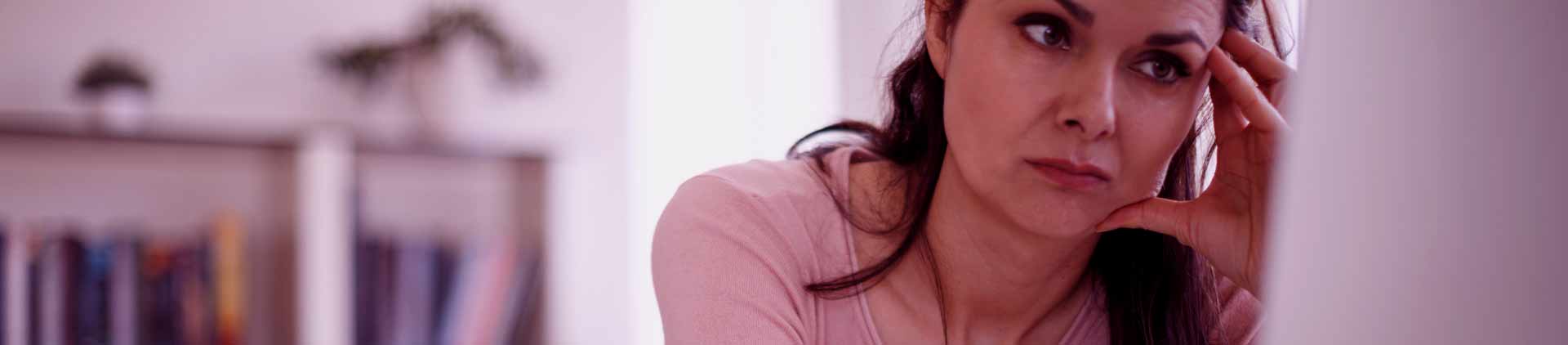 Mulher olhando o computador com olhar impaciente por causa de monitor piscando