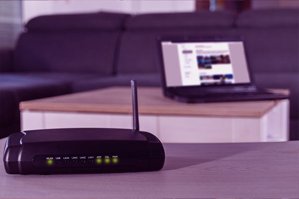 Imagem de um roteador ligado e configurado com as luzes verdes acesas. 