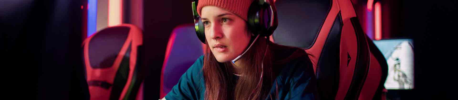Menina de frente com expressão concentrada  jogando em seu computador. 