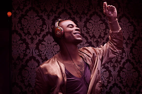 Homem ouvindo playlist de música em um headphone e sorrindo enquanto dança
