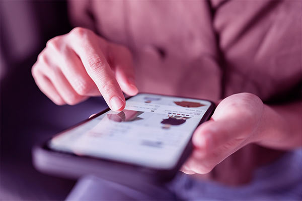 Mulher segurando celular em uma loja online conferindo preços de produtos