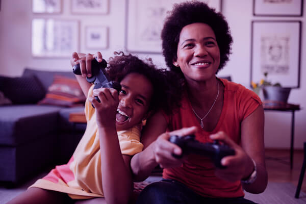 Imagem de mãe e filha jogando videogame