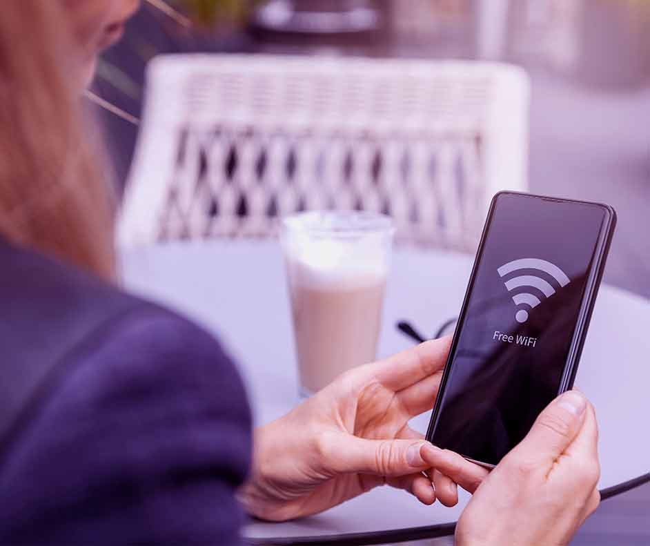 Mulher segurando celular com ilustração de Wi-Fi na tela e a senha logo abaixo