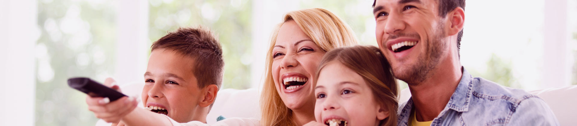 Imagem de uma família assistindo televisão.