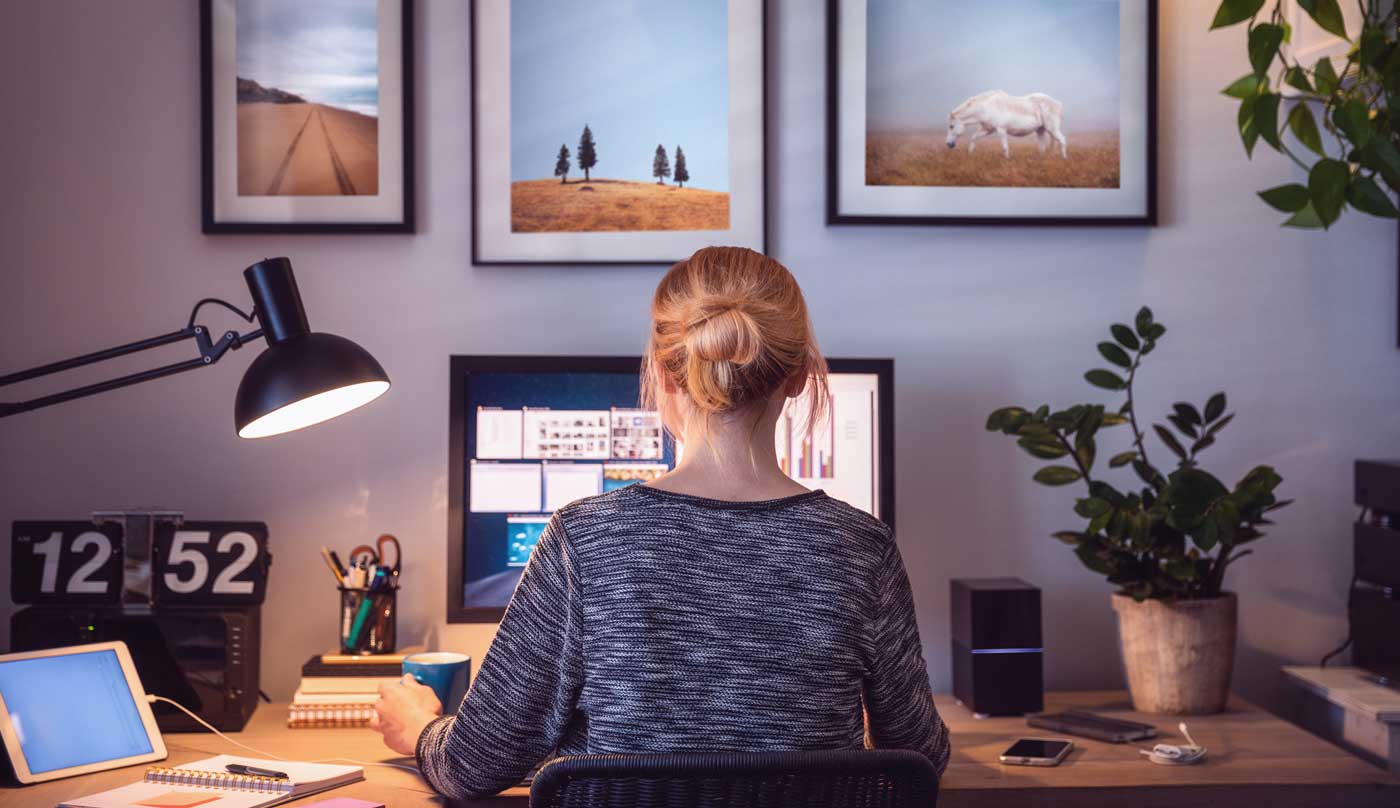 Imagem de uma mulher trabalhando no computador e otimizando o uso das telas