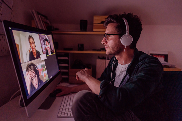 Imagem de um homem participado de uma reunião online no computador.