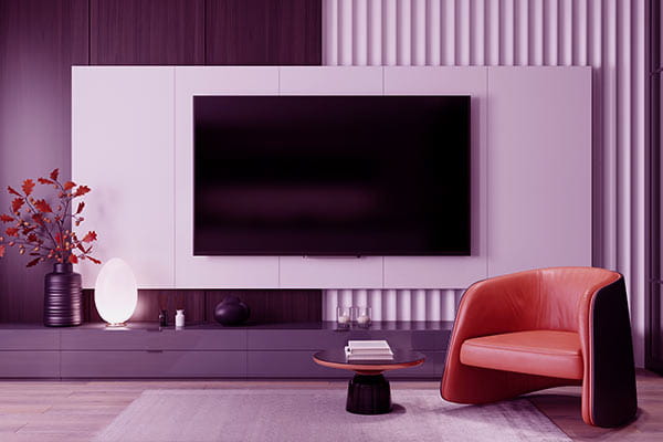 Sala de estar com uma poltrona, mesa de centro e uma TV sem sinal e imagem instalada na TV