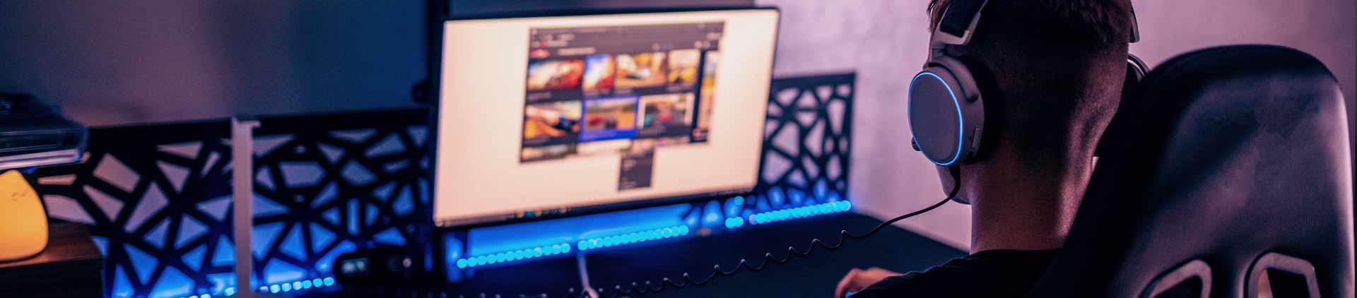 Garoto concentrado, de costas, mexendo em um PC que recebeu um upgrade para jogos