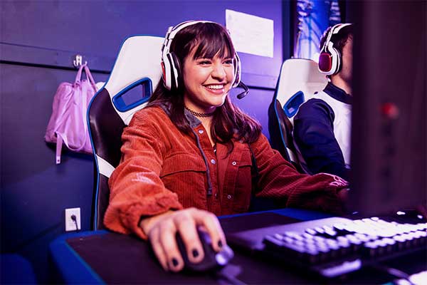 Moça em uma mesa gamer com headphone jogando em um PC gamer com upgrade