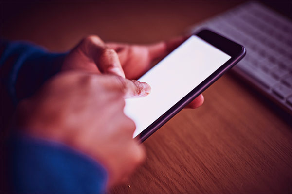 Mão negra acessando o celular 