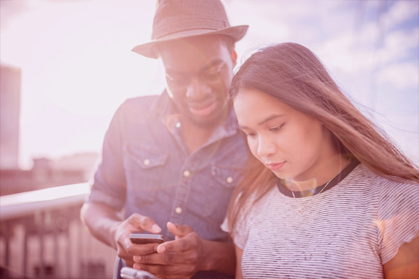 Homem e mulher verificando mensagem no celular no WhatsApp Pay