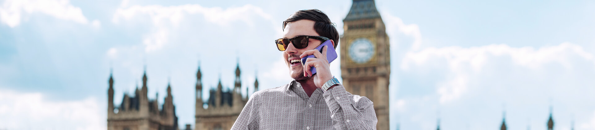 Um homem com oculos conversando no celular